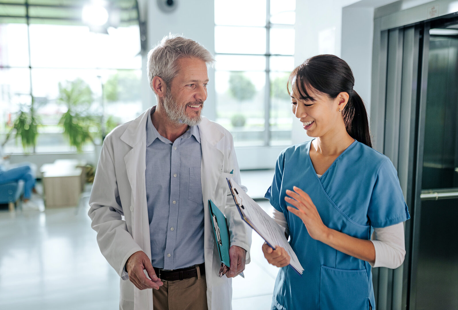 A middle-aged male doctor and a middle-aged female doctor are walking and talking