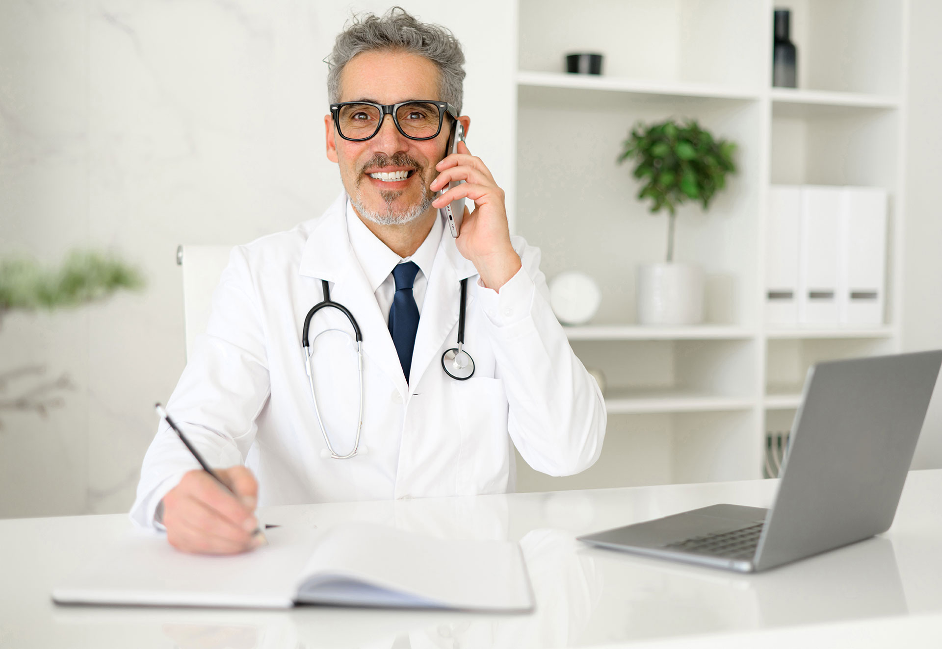 Erfahrener, selbstbewusster Oberarzt mit grauen Haaren beim Telefonat