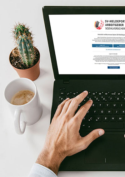 A man's hand holding a laptop