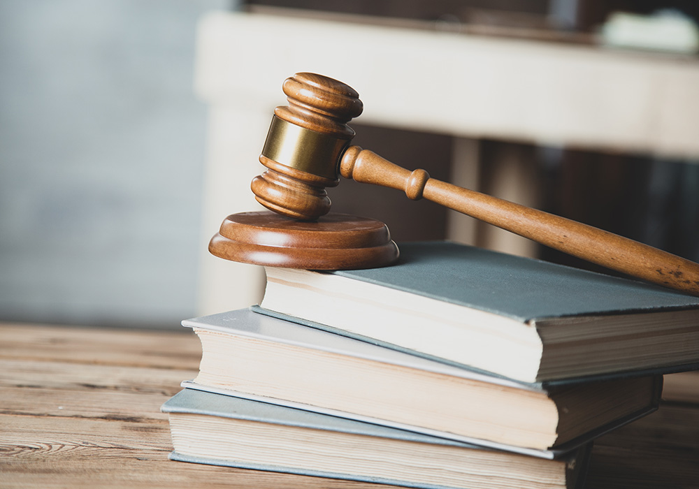 A wooden mallet on the law books on the desk
