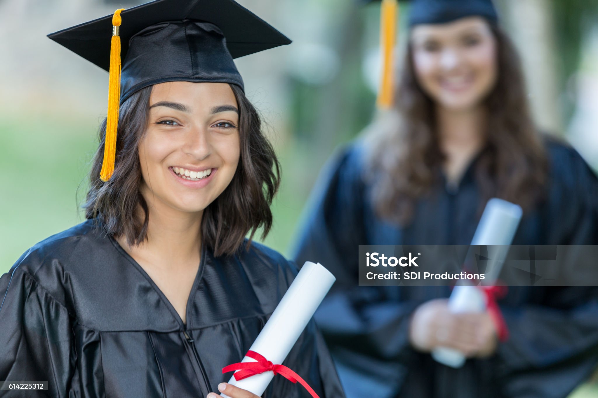 Junge Frau hält Ihre Urkunde für die bestandene Arztprüfung in den Händen