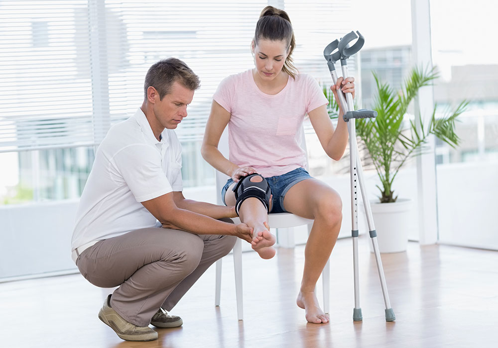 Bei der Reha: Arzt untersucht das Knie seiner Patientin