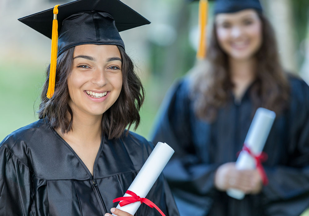 Junge Frau hält Ihre Urkunde für die bestandene Arztprüfung in den Händen